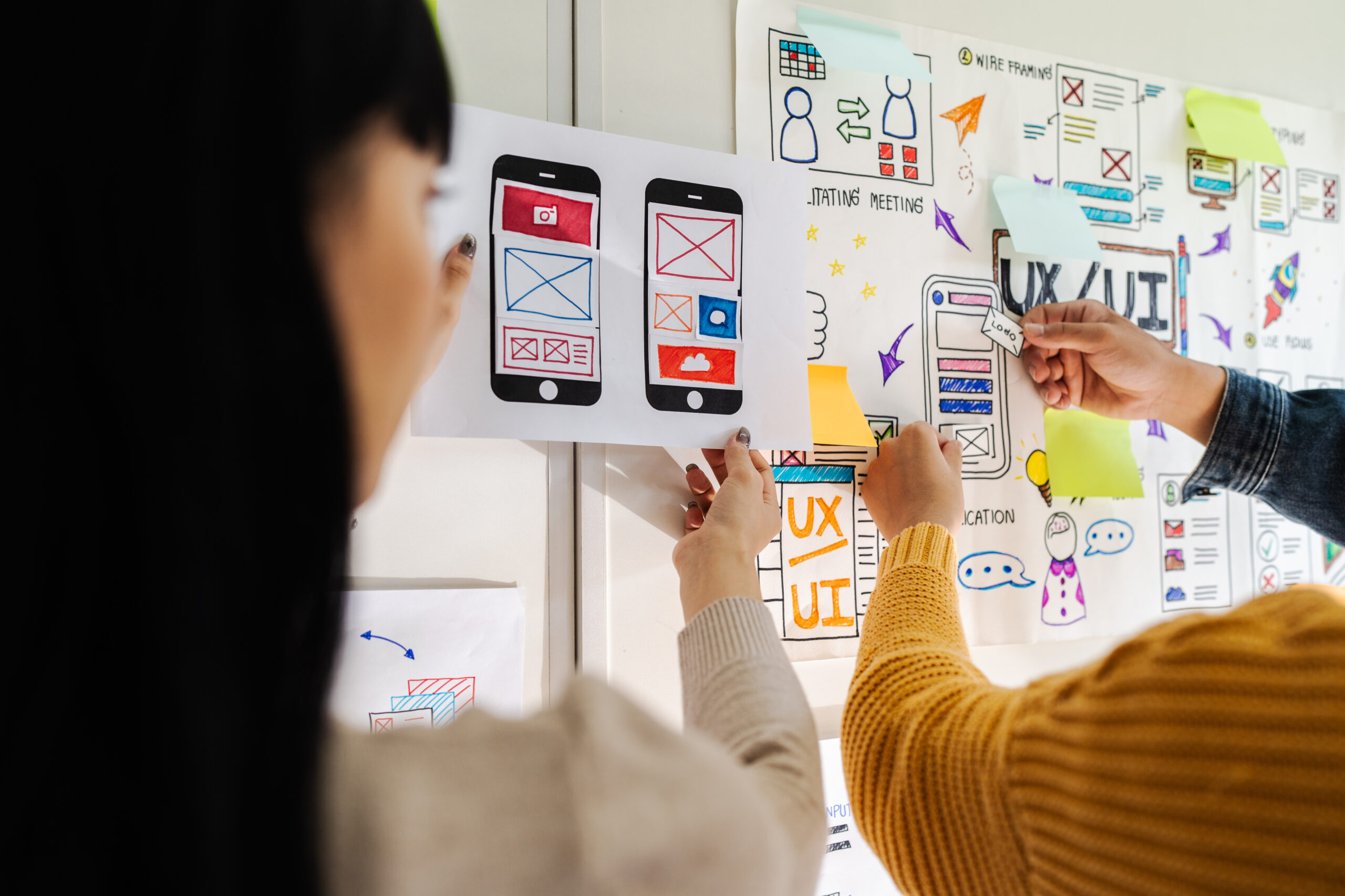 Close up ux developer and ui designer brainstorming interface wireframe design.Creative digital development agency