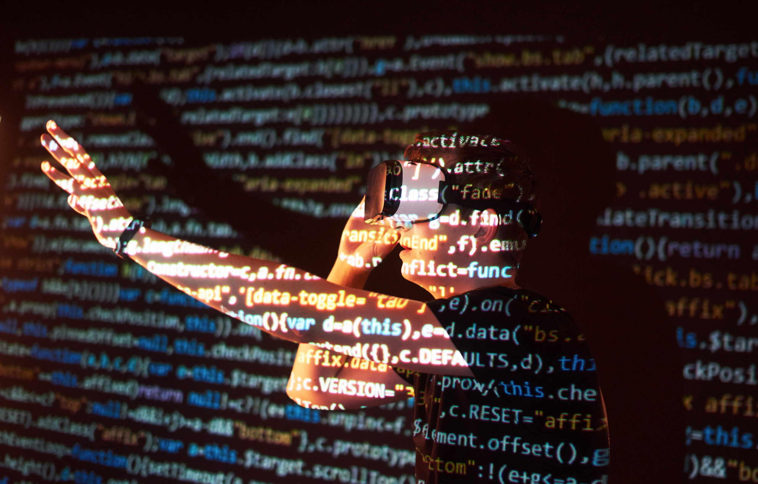 Double exposure of a caucasian man and Virtual reality headset is presumably a gamer or a hacker cracking the code into a secure network or server, with lines of code
