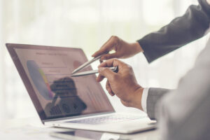 Image of two young businessmen using touchpad at meeting
