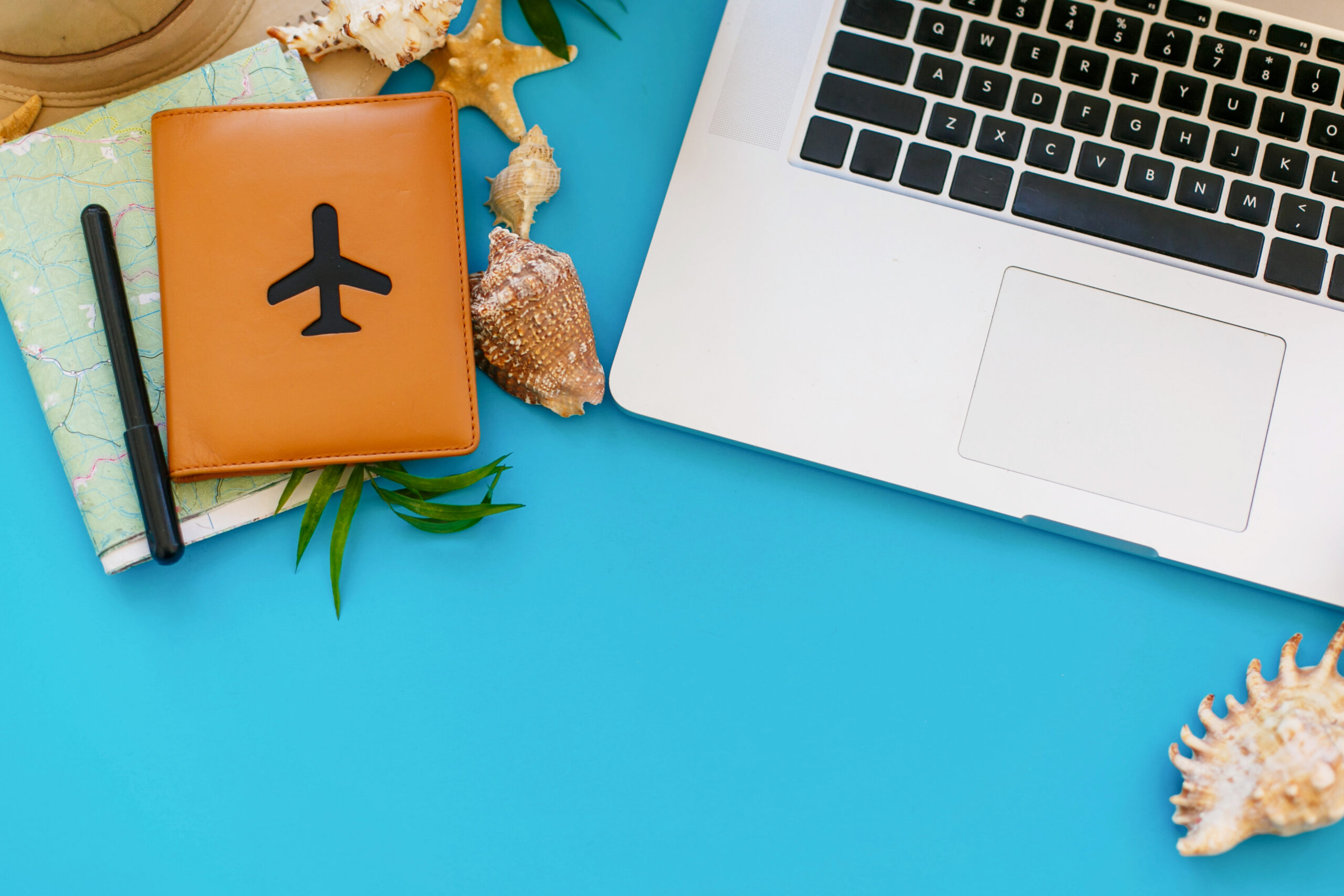 Laptop with empty screen, pineapple in sunglasses, passport, ma