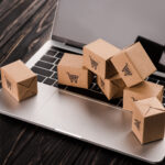 small carton boxes on laptop with blank screen, e-commerce concept
