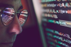Hacker using computer, smartphone and coding to steal password and private data