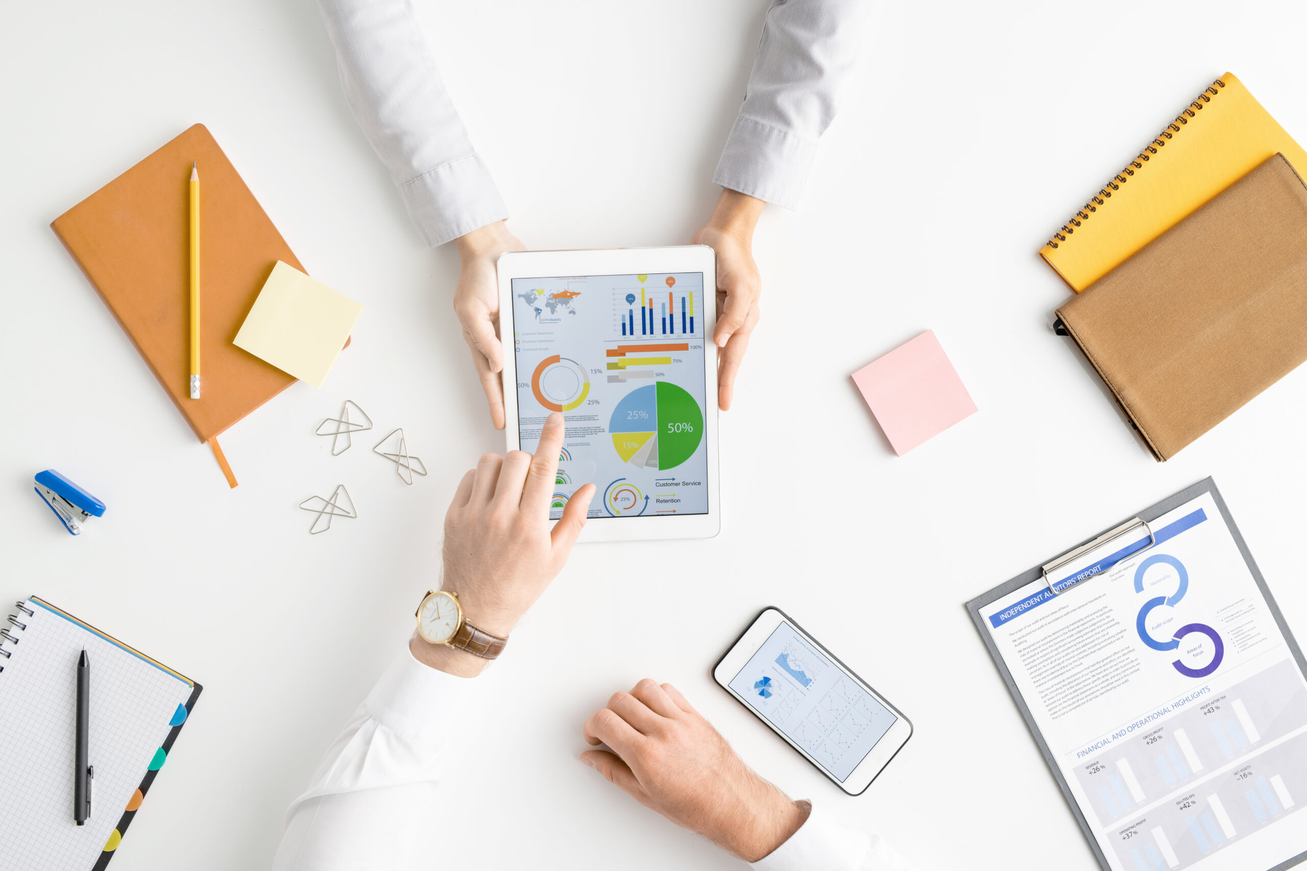 View of hands of two contemporary analysts or brokers discussing financial data