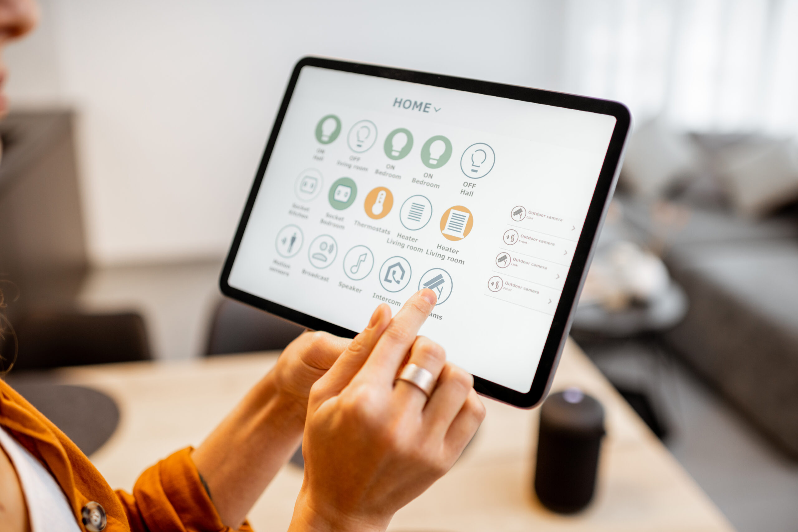 Woman controlling smart devices with a digital tablet at home